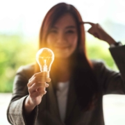 Closeup image of a thinking woman holding and showing glowing li
